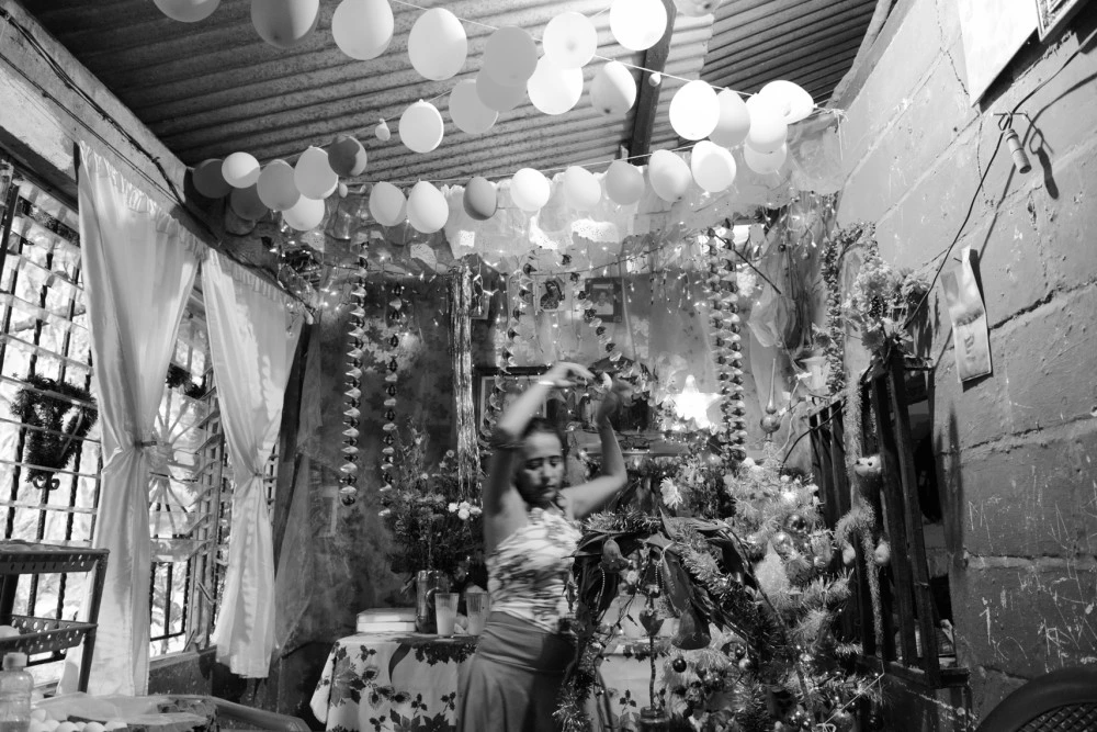 A woman with Christmas decorations in the small storefront inside her home where she sells food to migrants near the freight train tracks for "La Bestia," a freight train many migrants used to ride north.The U.S.-funded Plan Frontera Sur has increased enforcement on the train, so migrants have turned instead to walking and taking buses. This is a particularly dangerous area for them, with many robberies and attacks.