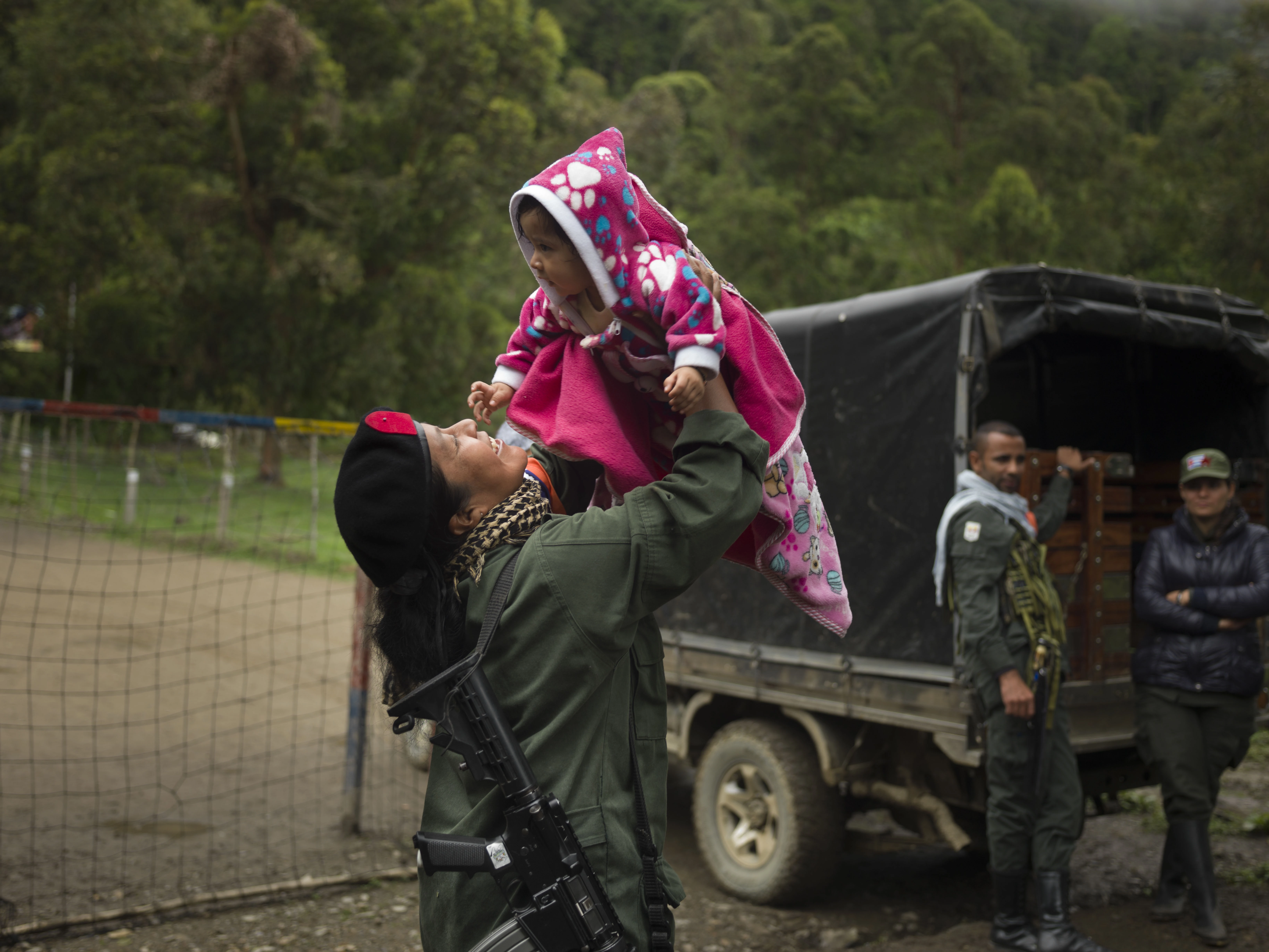 COLOMBIA. 2017. A fighter playing with a comrade’s child. For the first time since FARC’s formation, female members are allowed to keep their babies with the permission of their commander.