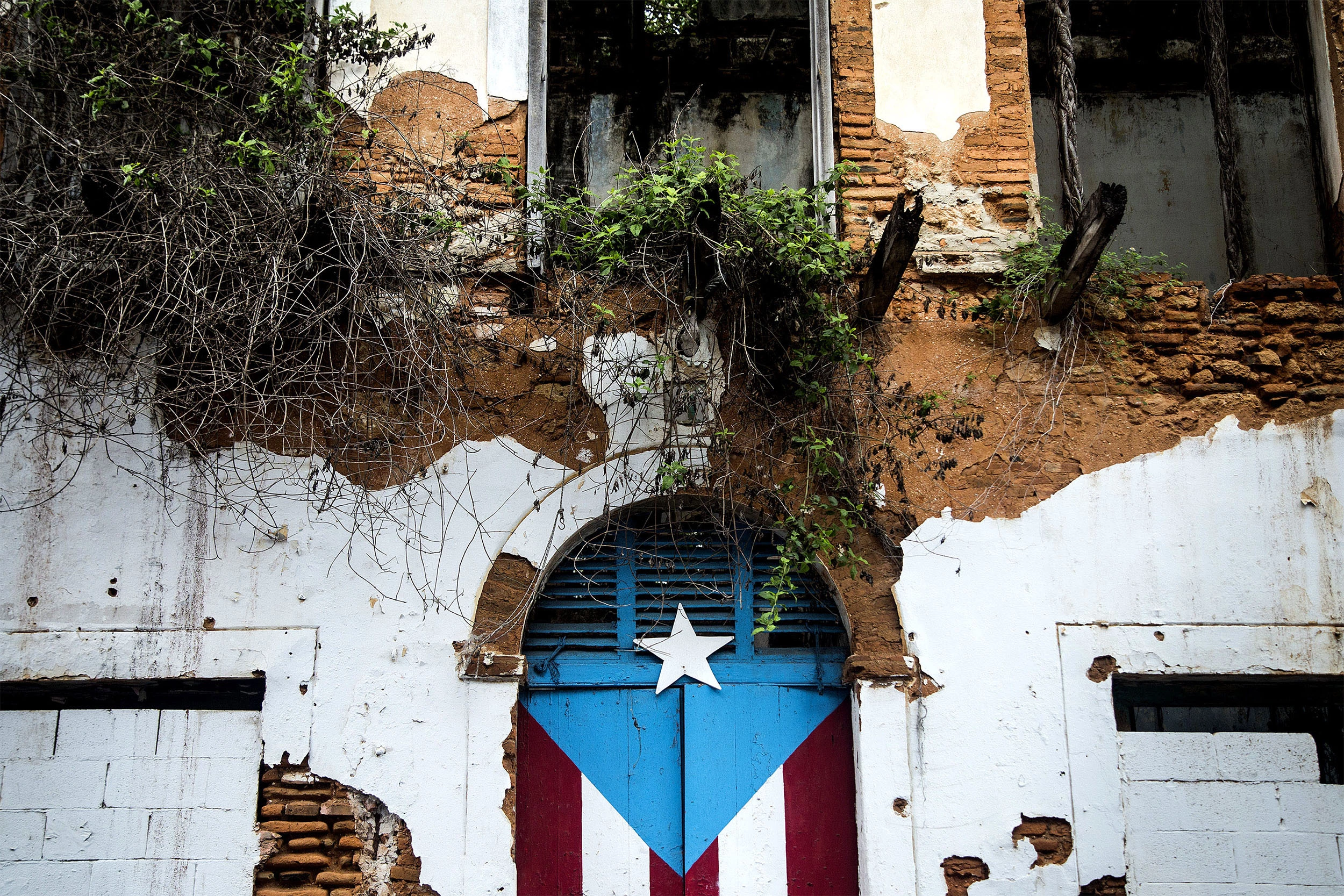 A Puerto Rican flag is painted on the doorway of an abandoned building in San Juan, Puerto Rico, on May 1, 2016.