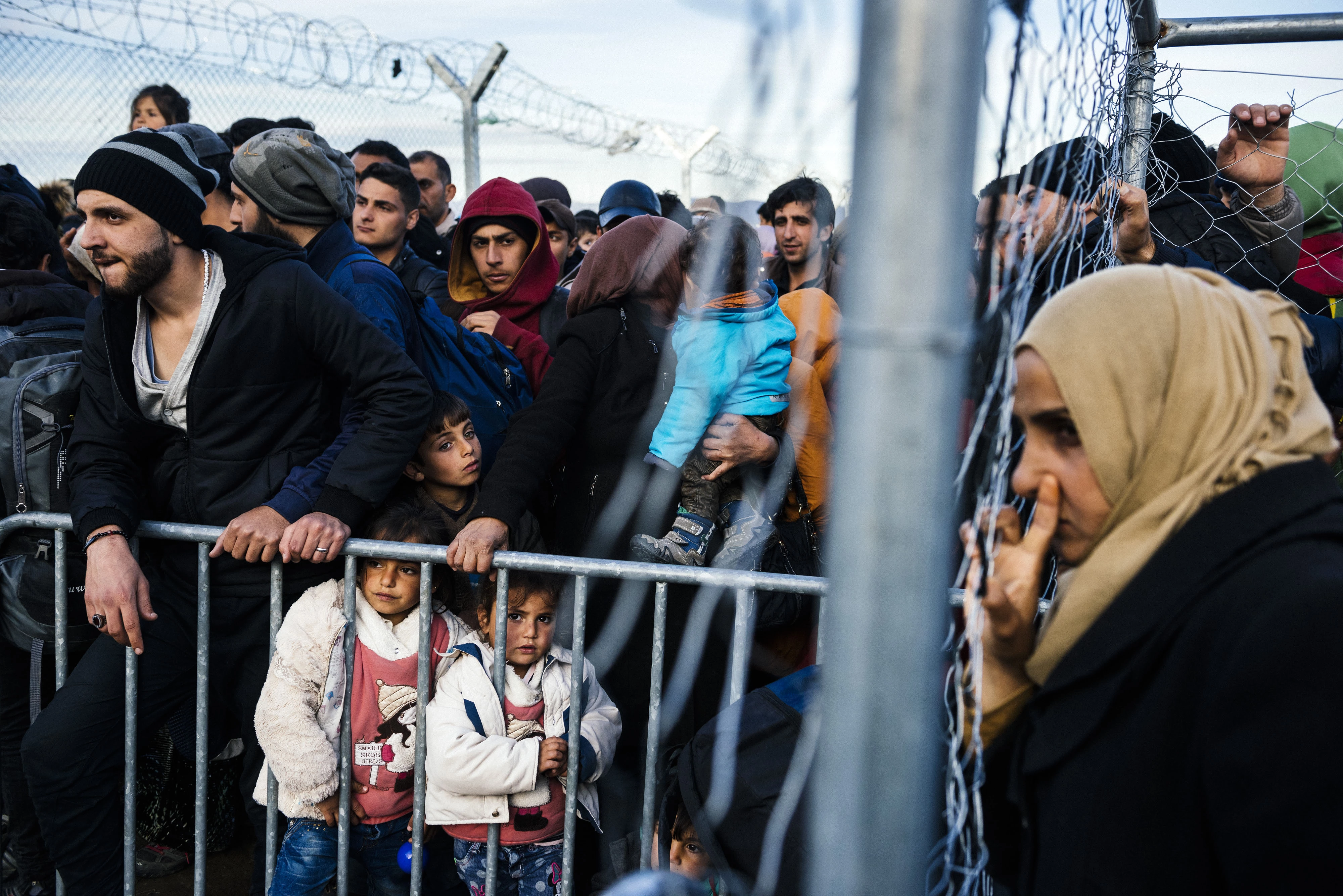 TOPSHOT - Migrants and refugees gather close to the gate at the Greek-Macedonian border near the Greek village of Idomeni, on March 5, 2016, where thousands of people wait to cross the border into Macedonia.<br />  Some 13,000 refugees are crammed in unhygienic conditions on Greece's border with Macedonia, officials said on March 5, 2016, with all eyes on a key EU-Turkey summit on March 7 that is seen as the only viable solution to the crisis. / AFP / DIMITAR DILKOFF        (Photo credit should read DIMITAR DILKOFF/AFP/Getty Images)
