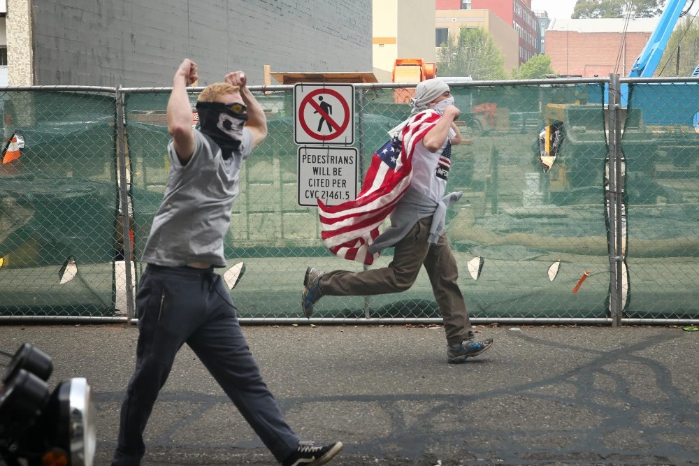 BERKELEY, CA - APRIL 15: Trump supporters chase after protesters at a "Patriots Day" free speech rally on April 15, 2017 in Berkeley, California. More than a dozen people were arrested after fistfights broke out at a park where supporters and opponents of President Trump had gathered. (Photo by Elijah Nouvelage/Getty Images)