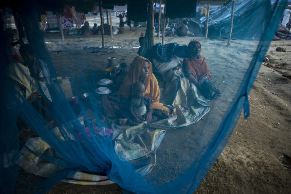 KUTUPALONG, BANGLADESH - SEPTEMBER 29: Women are seen behind a mosquito net September 29 in Kutupalong refugee camp, Bangladesh. Over a half a million Rohingya refugees have fled into Bangladesh from the horrific violence in Rakhine state in Myanmar causing a humanitarian crisis. (Photo by Paula Bronstein/Getty Images)