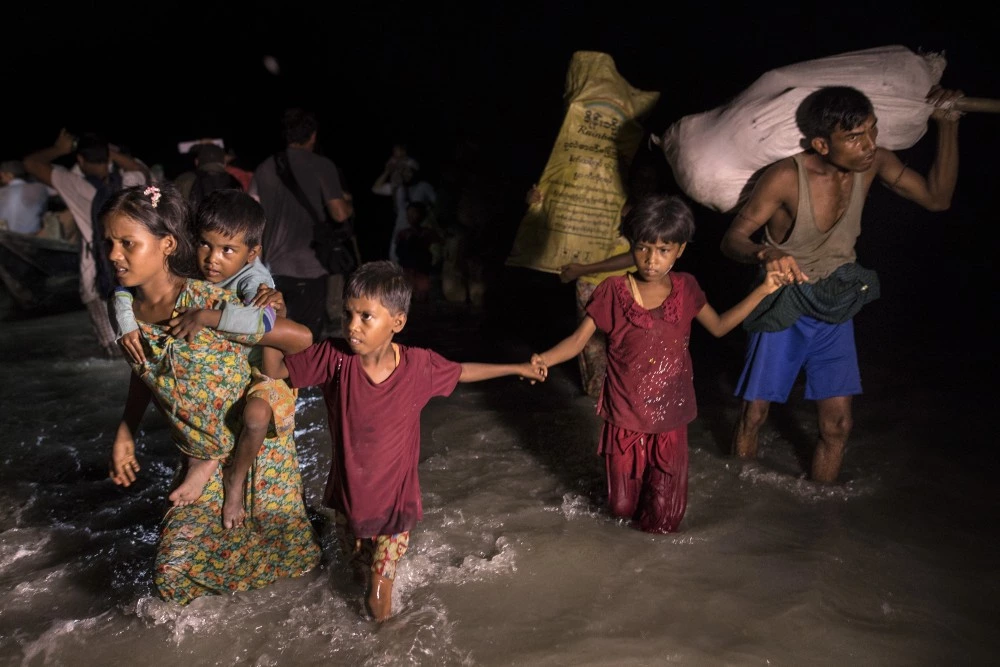SHAH PORIR DWIP, BANGLADESH - SEPTEMBER 30: Boats full of people continue to arrive along the shores of the Naf River as Rohingya come in the safety of darkness September 30, on Shah Porir Dwip island, Cox's Bazar, Bangladesh. Over a half a million Rohingya refugees have fled into Bangladesh since late August during the outbreak of violence in Rakhine state causing a humanitarian crisis in the region with continued challenges for aid agencies. (Photo by Paula Bronstein/Getty Images)