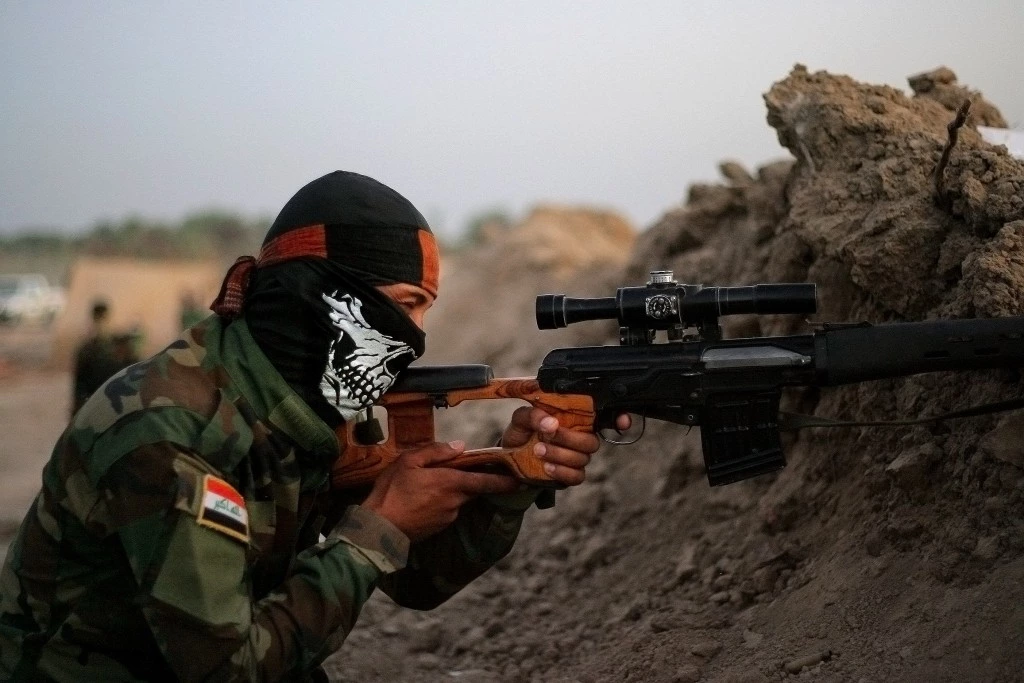 In this Sunday, Sept. 28, 2014 photo, an Iraqi Shiite militiaman aims his weapon after clashes with militants from the Islamic State group, in Jurf al-Sakhar, 43 miles (70 kilometers) south of Baghdad, Iraq. (AP Photo)