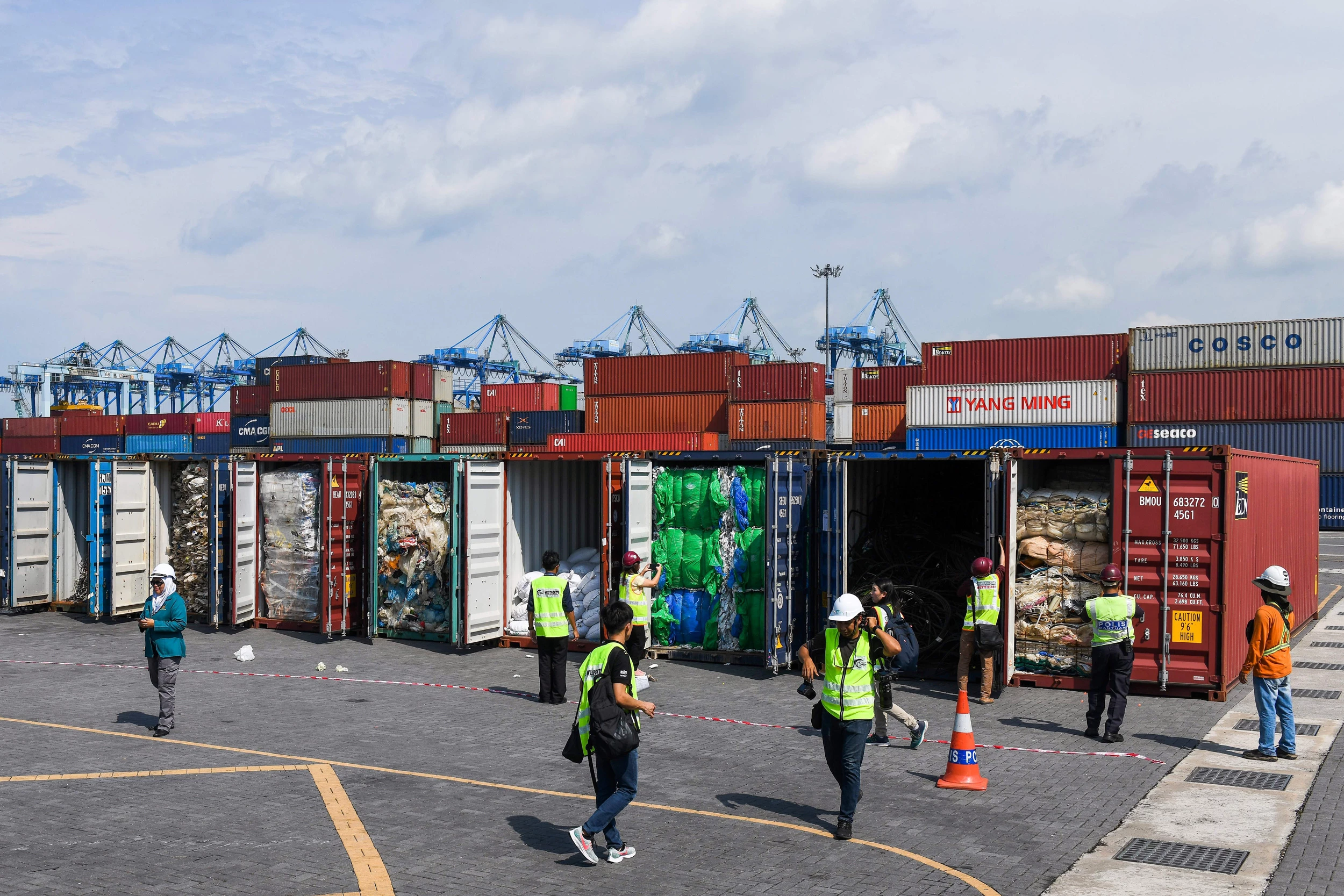 Malaysian officials and journalists inspect containers filled with plastic waste shipment before sending back to the country of origin in Port Klang, west of Kuala Lumpur on May 28, 2019. (Photo by Mohd RASFAN / AFP)        (Photo credit should read MOHD RASFAN/AFP via Getty Images)