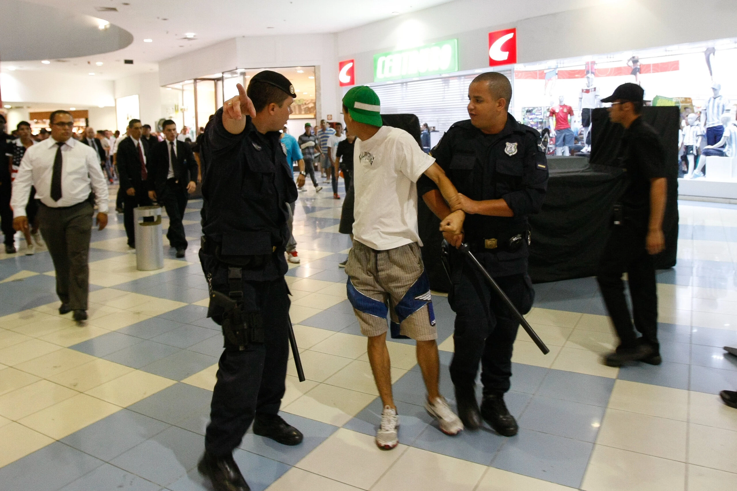 Em 2013, policiais retiram jovem do shopping Internacional de Guarulhos (SP). Após lojistas acionarem a polícia com denúncias de roubo, a PM prendeu 15 menores. Foto: Robson Ventura/Folhapress.