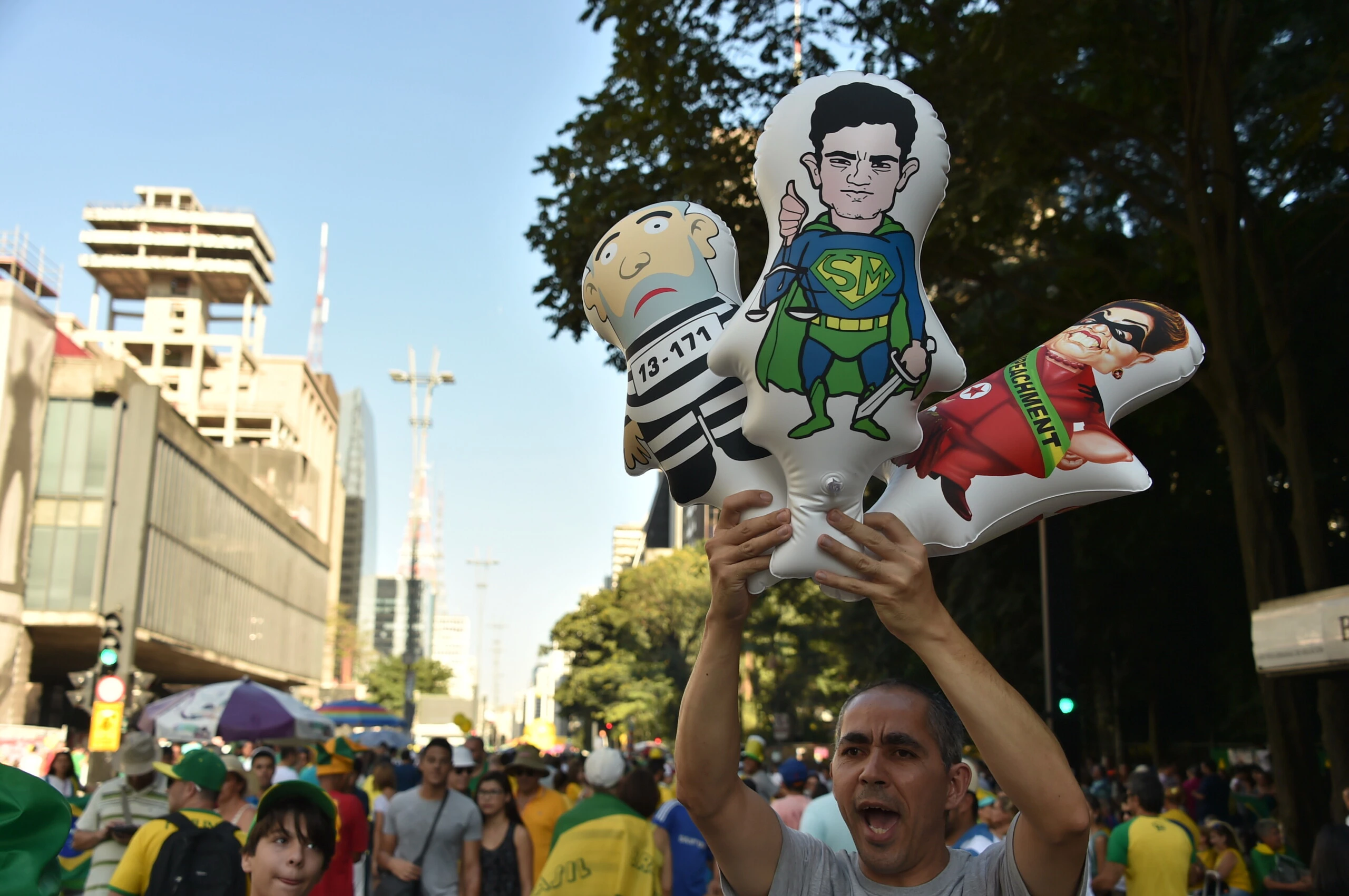 A mand holds balloons depicting (L-R) Brazilian former President Luiz Inacio Lula Da Silva, Brazilian Judge Sergio Moro and Brazilian President Dilma Rousseff during a demo in support of Rousseff's impeachment in Sao Paulo, Brazil on April 17, 2016. Rousseff risks being driven from office if the lower house votes in favor of an impeachment trial Sunday in Brasilia. / AFP / NELSON ALMEIDA        (Photo credit should read NELSON ALMEIDA/AFP/Getty Images)