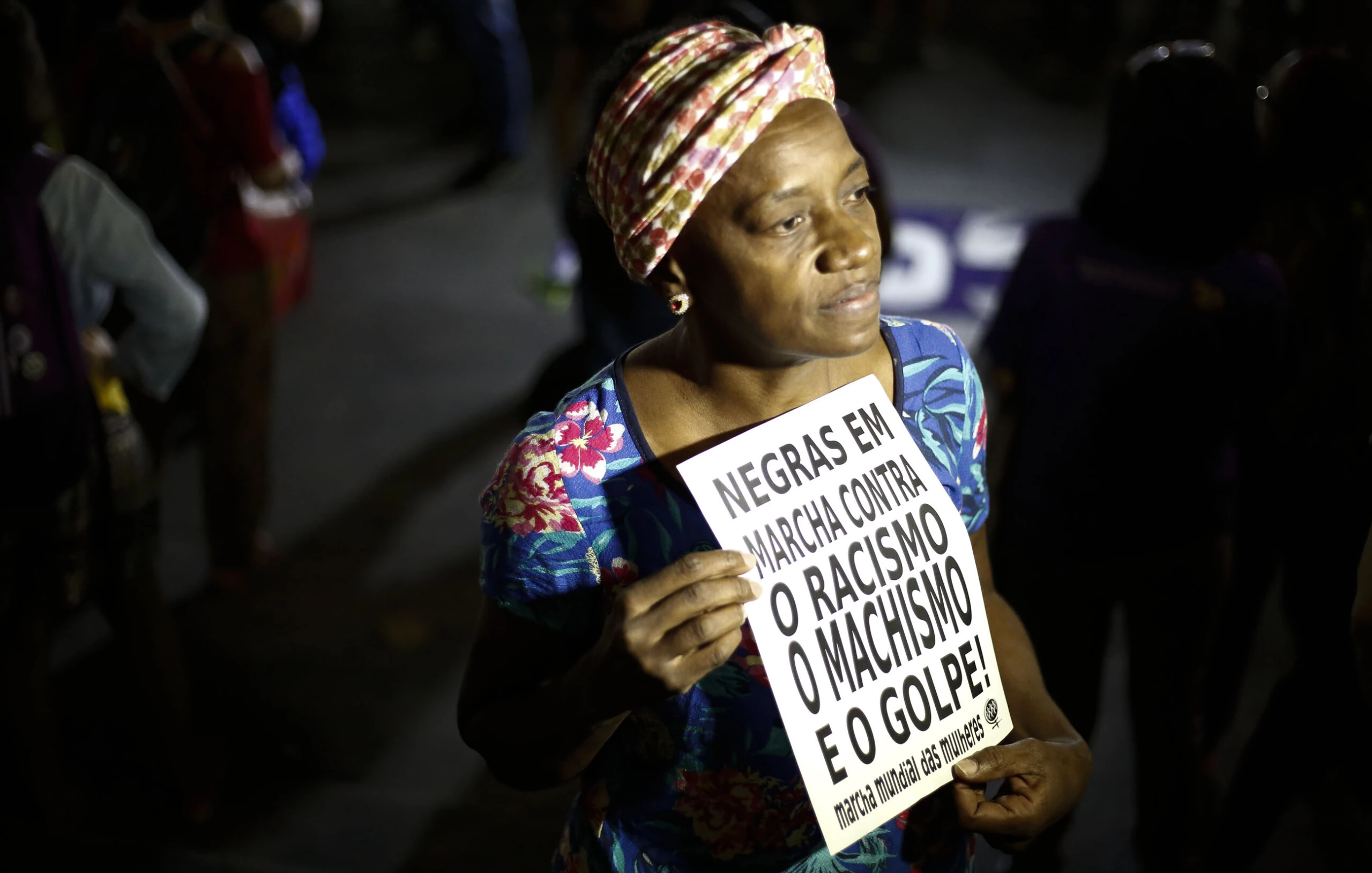 A woman holds a sign reading "Black women march against racism, male chauvinism and the coup" during a protest against the president of the Brazilian lower house Eduardo Cunha, Brazilian Vice-President Michel Temer and Jair Bolsonaro -a far right member of Congress who has praised Brazil's former military dictatorship and torture of opponents in the 1970s- in Sao Paulo, Brazil on April 26, 2016. Six out of 10 Brazilians want snap elections to resolve the country's political crisis in which leftist President Dilma Rousseff faces impeachment, a poll released Tuesday said. / AFP / Miguel Schincariol        (Photo credit should read MIGUEL SCHINCARIOL/AFP/Getty Images)