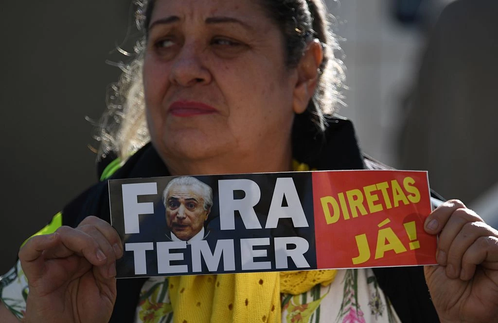 A supporter of former Brazilian president Dilma Rousseff protests against President Michel Temer during a campaign rally for Jandira Feghali, Communist Party candidate for mayor of Rio de Janeiro, where Rousseff gave a speech in Rio de Janeiro on September 21, 2016. / AFP / VANDERLEI ALMEIDA        (Photo credit should read VANDERLEI ALMEIDA/AFP/Getty Images)