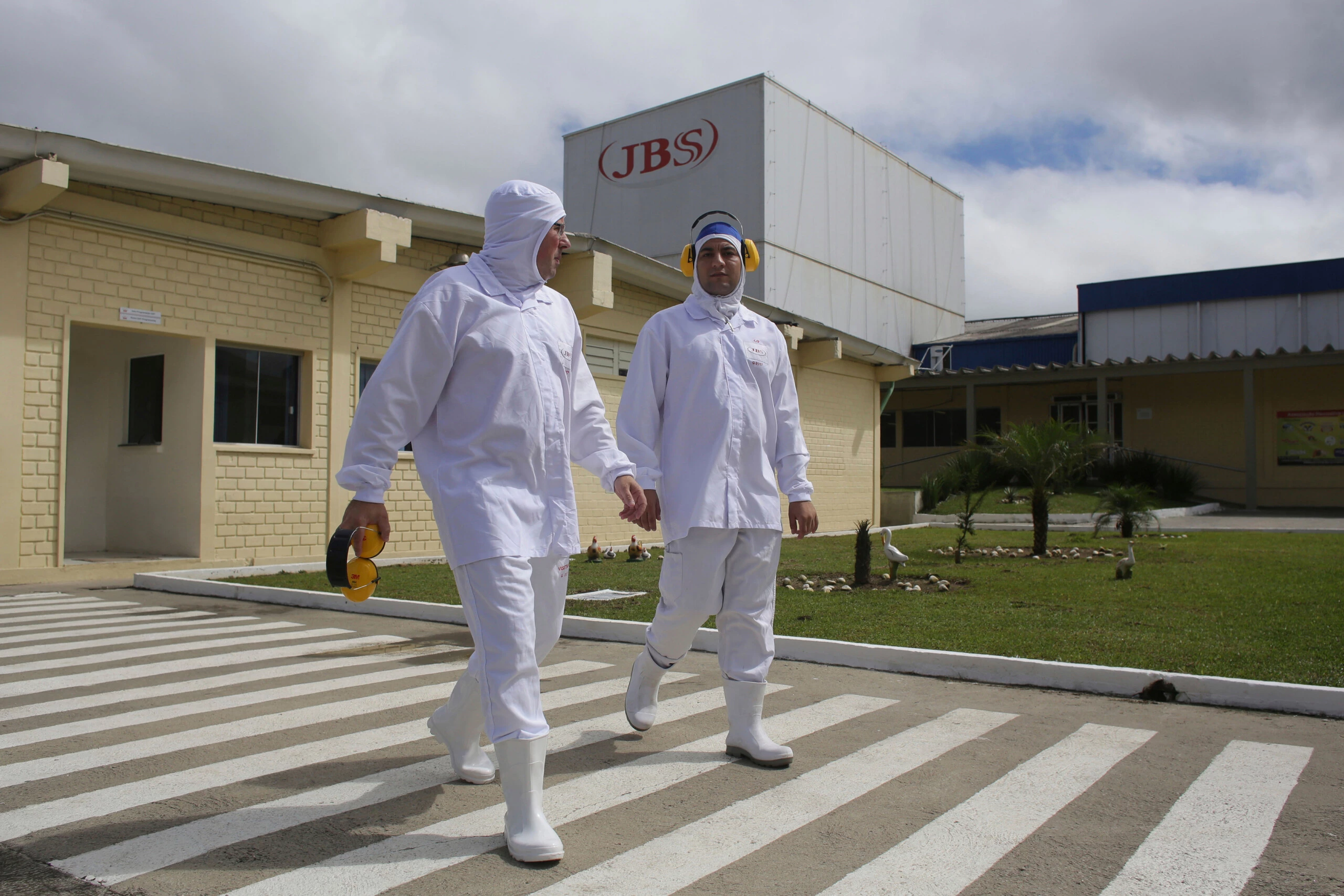FILE - In this March 21, 2017 file photo, employees walk on the plant grounds of meatpacker JBS, in Lapa, in the Brazilian state of Parana. The European Union said Thursday, April 19, 2018, to ban meat imports from 20 Brazilian plants amid concerns about sanitary controls. The decision mostly affects poultry.  (AP Photo/Eraldo Peres, File)