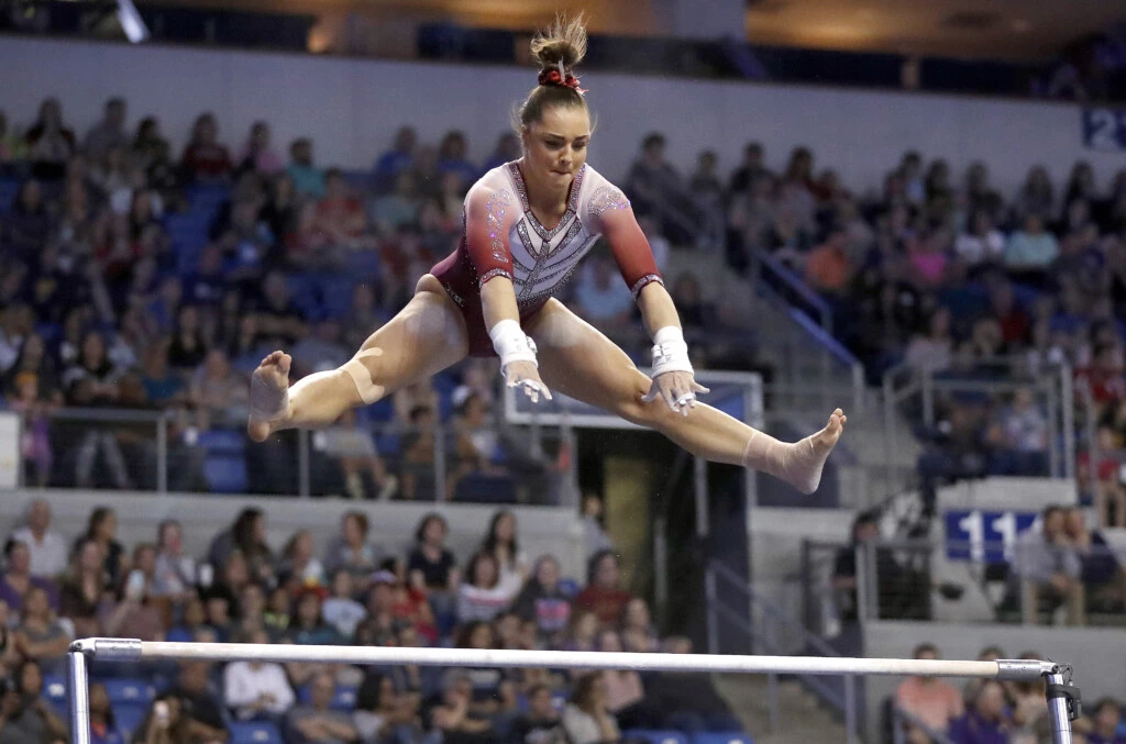 FILE- In this April 15, 2017, file photo, Oklahoma's Maggie Nichols competes on the uneven parallel bars during the NCAA college women's gymnastics championships in St. Louis. Nichols, a former Olympic hopeful, says she is among more than 100 women and girls who say they are victims of sexual abuse by a now-imprisoned Michigan sports doctor. She said in a statement Tuesday, Jan. 9, 2018, that Dr. Larry Nassar violated her innocence at the Karolyi Ranch Olympic training camp in Texas.  (AP Photo/Jeff Roberson, File)