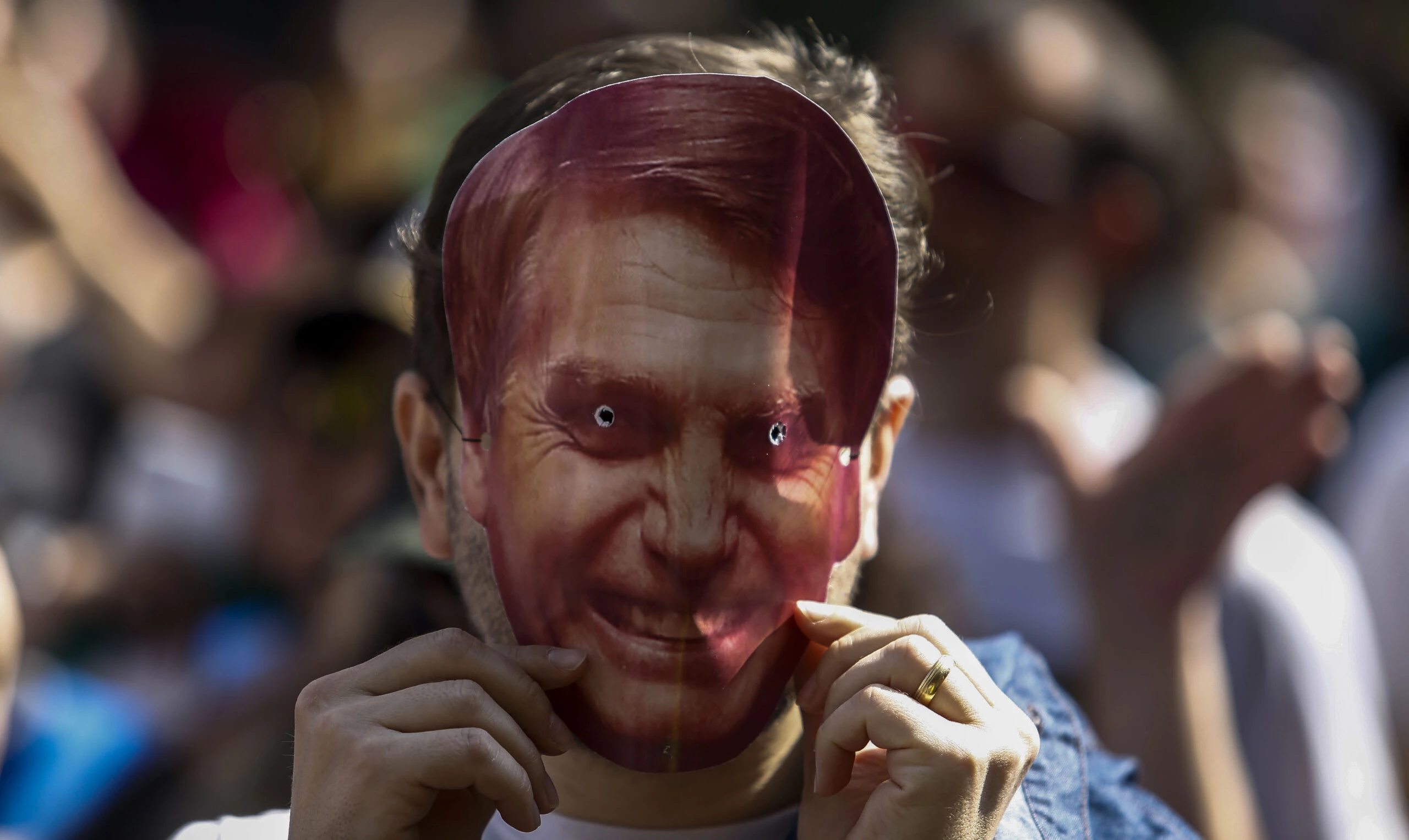 A supporter of Brazilian right-wing presidential candidate Jair Bolsonaro wears a mask of him during a rally at Paulista Avenue in Sao Paulo, Brazil on September 09, 2018. - Supporters of far-right presidential candidate Jair Bolsonaro demonstrated in support of the frontrunner on Sunday, who is convalescing after being stabbed while campaigning several days before. Bolsonaro is hospitalized in the Albert Einstein Hospital in Sao Paulo, which said Sunday that his condition is improving but that he was still receiving nutrients intravenously. (Photo by Miguel SCHINCARIOL / AFP)        (Photo credit should read MIGUEL SCHINCARIOL/AFP/Getty Images)
