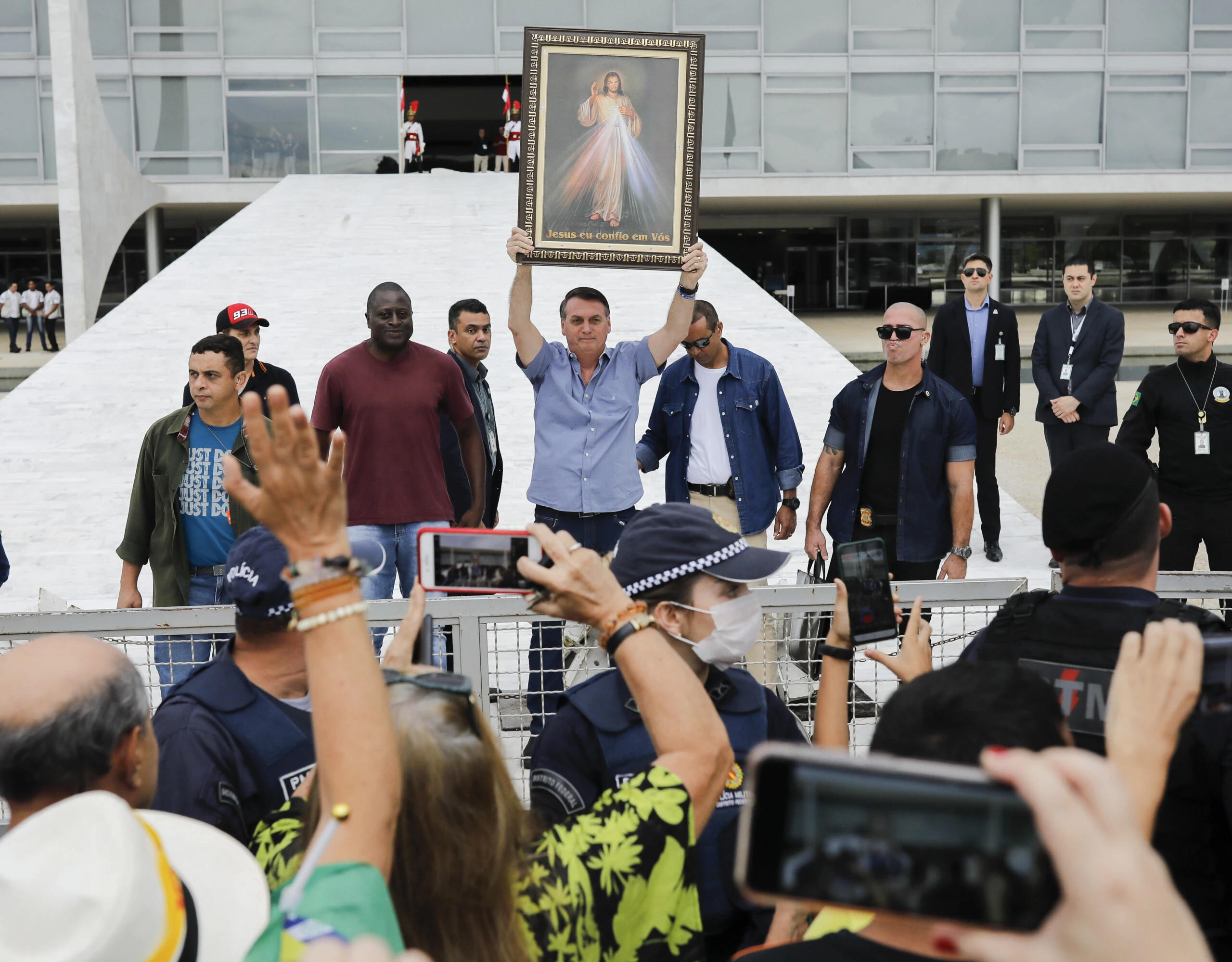 Brazilian President Jair Bolsonaro raises an image of Jesus Christ during a gathering with Catholic and anti-abortion supporters in front of Planalto Palace in Brasilia on April 18, 2020 amid the coronavirus COVID-19 pandemic. - Brazilian President Jair Bolsonaro on Friday defended his decision to restart economic activity in the middle of the coronavirus pandemic, after sacking his health minister over differences in how to tackle the disease. (Photo by Sergio LIMA / AFP) (Photo by SERGIO LIMA/AFP via Getty Images)