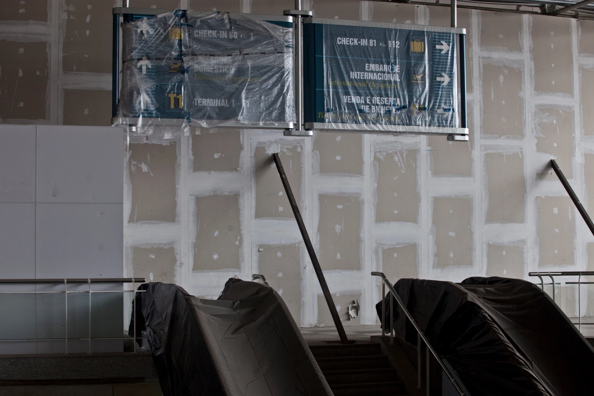 Escalators and signs sit under plastic during construction at the Galeao International Airport in Rio de Janeiro, Brazil, on Tuesday, Sept. 3, 2013. Operated by Infraero Aeroportos, Galeao is Brazil's largest airport. Photographer: Dado Galdieri/Bloomberg via Getty Images