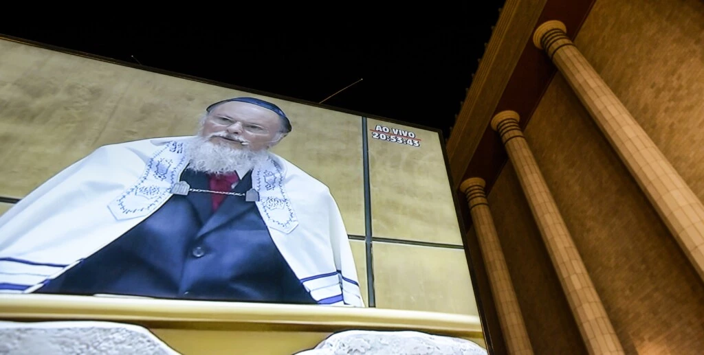 Billionaire Edir Macedo, owner and chairman of Rede Record de Televisao Angola Lda, is projected on a screen displayed outside a replica of Solomon's Temple during its inauguration ceremony in Sao Paulo, Brazil, on Thursday, July 31, 2014. Billionaire Edir Macedo's temple spans two city blocks and cost 680 million reais ($300 million) to erect. Macedo's net worth has grown to $1.5 billion since he bought the Record TV network in 1989 with a $45 million interest-free loan from the Universal Church of the Kingdom of God, which he founded, according to the Bloomberg Billionaires Index. Photographer: Paulo Fridman/Bloomberg via Getty Images