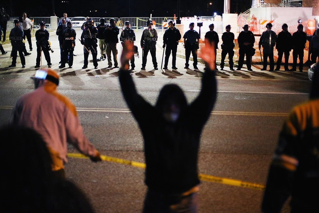Policiais se posicionam diante de manifestantes em frente a uma delegacia, em meio aos protestos pela morte de Michael Brown, 18 anos, em 22 de outubro de 2014, em Ferguson, Missouri