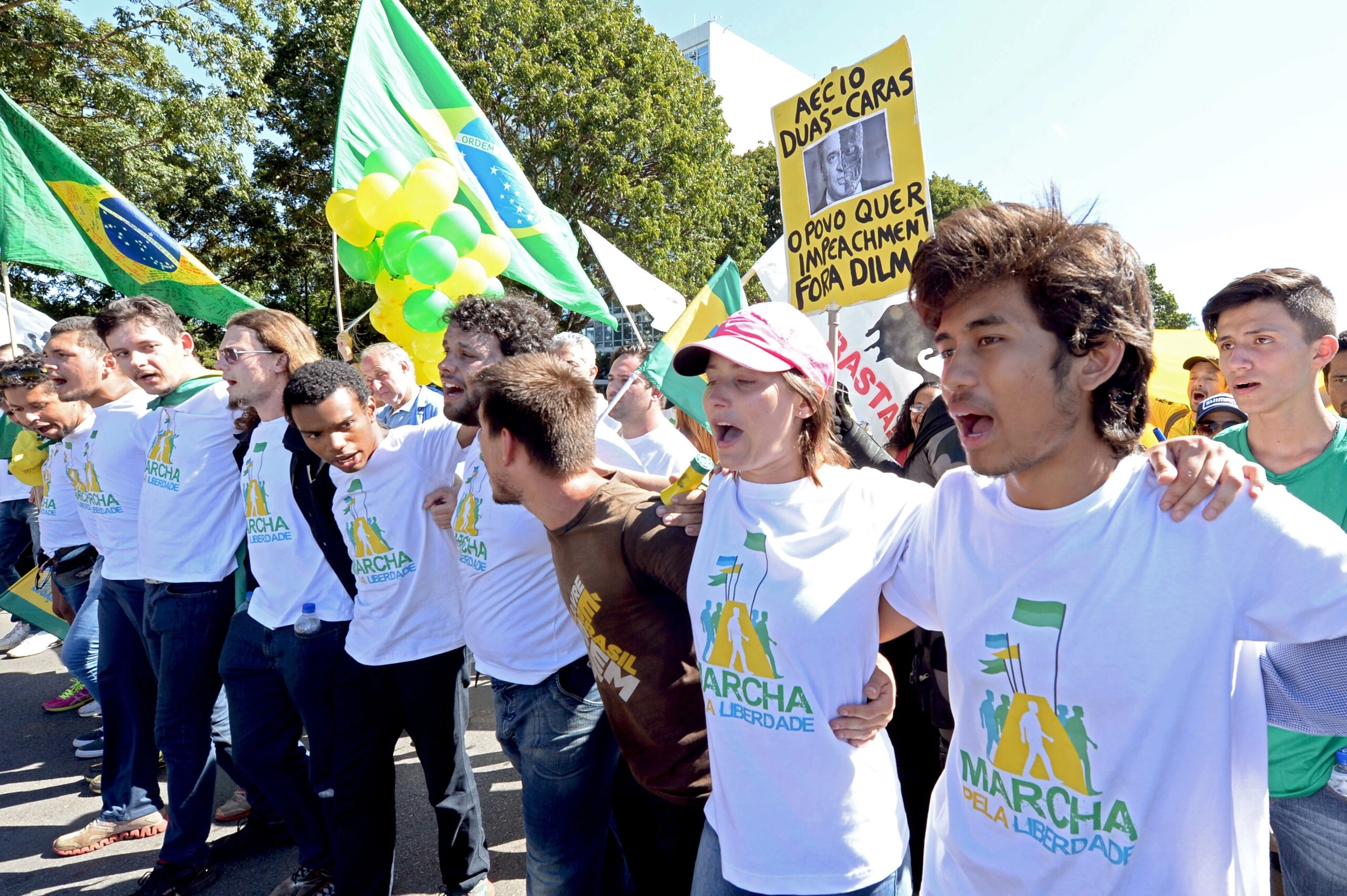 Kim Kataguiri (R), leader of the Free Brazil Movement (MBL), takes part in the March for Freedom in demand of President Dilma Rousseff's impeachment in Brasilia, Brazil on May 27, 2015. Kataguiri, a 19-year-old college drop out, is the face of MBL, a growing force which seeks to harness some of the energy of the 2013 protest movement which brought more than a million onto the streets. AFP PHOTO/EVARISTO SA        (Photo credit should read EVARISTO SA/AFP via Getty Images)