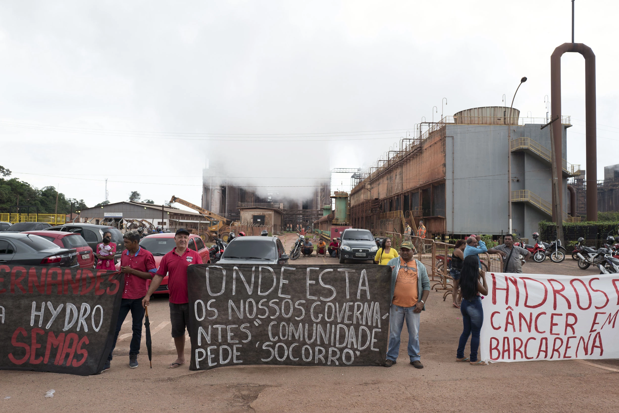 Demonstrators hold signs during a protest against Norsk Hydro ASA discharging untreated water into a nearby river in front of the company's alumina refinery in Barcarena, Para state, Brazil, on Wednesday, Feb. 28, 2018. A Brazilian judge ordered Norsk Hydro ASA to pay for residents to be tested for health problems related to possible contamination caused by leakage from the company's Amazonian alumina operations, court documents show. Photographer: Alessandro Falco/Bloomberg via Getty Images