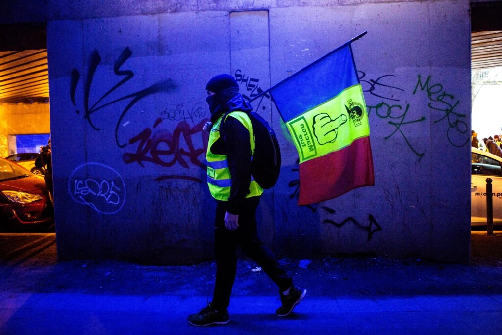 Manifestante de colete amarelo carrega uma bandeira francesa com as palavras “Macron mata” escritas, em Paris, em 12 de janeiro de 2019.