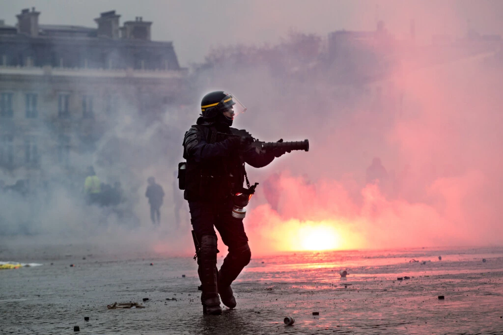 Policial de choque dispara bombas de gás lacrimogêneo contra manifestantes de coletes amarelos em Paris, em 12 de janeiro de 2019.
