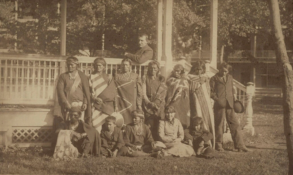 O fundador de Carlisle, Richard Henry Pratt, sentado ao centro do coreto, com um grupo de alunos Navajo recém-chegados à escola em 21 de outubro de 1882.