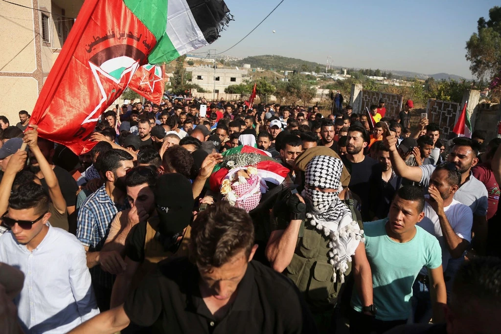 Palestinos carregam o cadáver de ‘Iz a-Din Tamimi, durante seu funeral em 6 de junho de 2018.