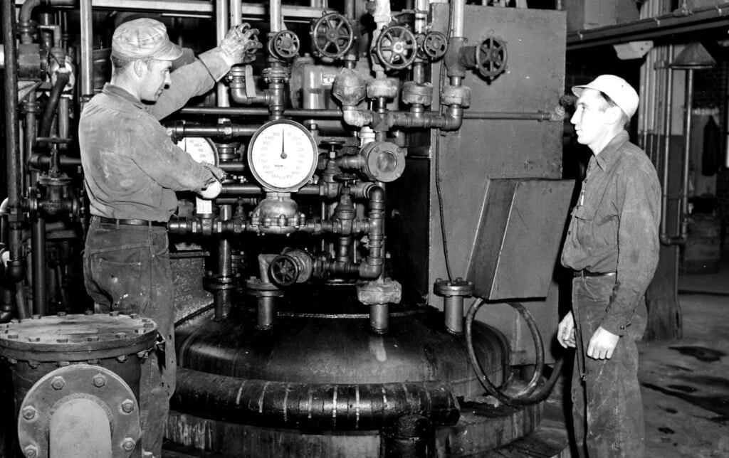 Trabalhadores cuidam de operações químicas para fabricação de corantes nas instalações da Chamber Works nos anos 1940.