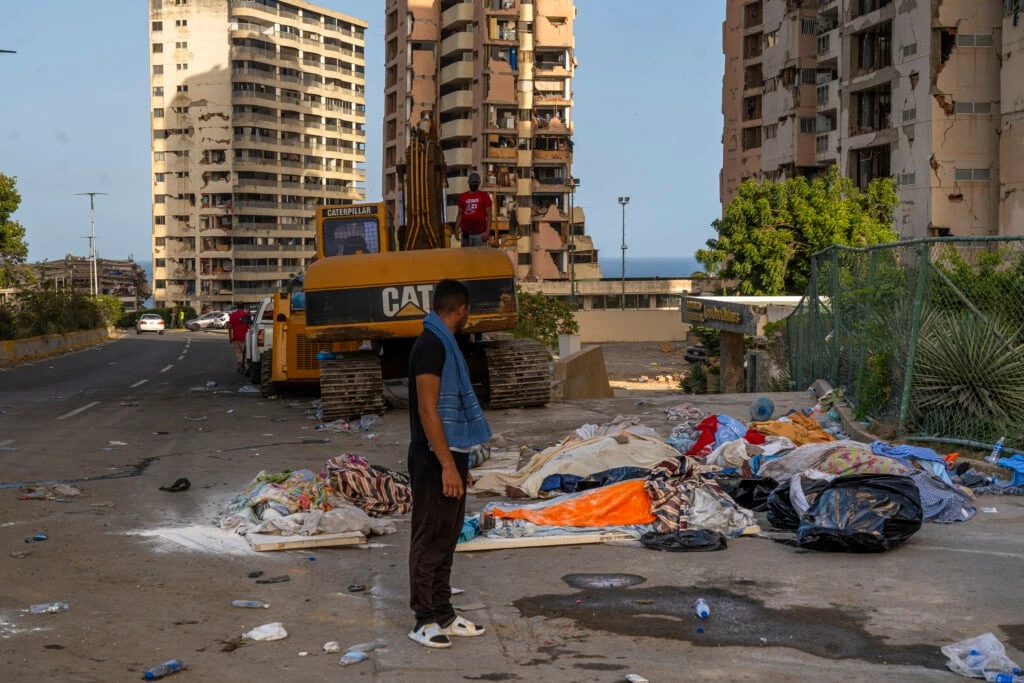 Cátia la Mara, Venezuela. Homem observa corpos que foram retirados de edifícios destruídos aguardando para serem levados para necrotério. (Yan Boechat)