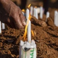 Josivaldo de Jesus Silva, 35, acende velas durante enterro de seu irmão Josivan de Jesus Silva, 31, morto em rebelião na penitenciária de Altamira, no sudoeste do Pará.