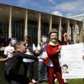 Members of the Avaaz online community organization stage in front of the Itamaraty Forein Ministry Palace the delivery of the Brazilian passport by Brazilian President Dilma Rousseff to Edward Snowden while U.S. President Barack Obama tries to stop her, in Brasilia, on February 13, 2014. Avaaz members have collected over a million signatures in favor of the asylum application for Snowden, the former CIA technician  that disclosed the spying by the U.S. government to millions of people, among whom President Rousseff and German Chancellor Angela Merkel. AFP PHOTO/Beto BARATA        (Photo credit should read BETO BARATA/AFP/Getty Images)