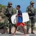 TOPSHOT - Brazilian Army members stand guard in Ipanema beach on July, 29, 2017, following the government decision to deploy some 8,500 soldiers to Rio de Janeiro state to fight organized crime and a spike in street violence.  / AFP PHOTO / Mauro PIMENTEL        (Photo credit should read MAURO PIMENTEL/AFP/Getty Images)