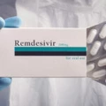 Medical worker holding pack of remdesivir pills