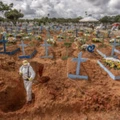 Worker wearing personal protective equipment (PPE) digs a grave at a cemetery in Manaus, Brazil, on Tuesday, Jan. 19, 2021. Severe oxygen shortages at hospitals in Brazil's Amazon prompted local authorities to impose a curfew and airlift patients to other states to deal with the onslaught of a second coronavirus wave. Photographer: Jonne Roriz/Bloomberg via Getty Images