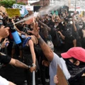 Policiais de Nova York jogam spray de pimenta na multidão de manifestantes reunidos no Barclays Center para protestar contra o recente assassinato de George Floyd em 29 de maio, no Brooklyn, Nova York.