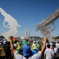 TOPSHOT - A man holds two signals in the shape of a gun during a pro-gun demonstration in support of Brazilian President Jair Bolsonaro in Brasilia, on July 9, 2021. (Photo by Sergio Lima / AFP) (Photo by SERGIO LIMA/AFP via Getty Images)