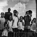 A group of children (and a few men) gaze from behind a barbed-wire fence that marks the boundary of the Moroka township in Soweta, Johannesburg, South Africa, April 21, 1950. (Photo by Margaret Bourke-White/The LIFE Picture Collection via Getty Images)