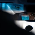 Um motorista da Uber usando uma máscara cirúrgica é visto pelo espelho em Manhattan em 15 de março de 2020.