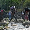 People taking irregular roads cross the Tachira river from Cucuta in Colombia to San Antonio del Tachira in Venezuela, near the Simon Bolivar international Bridge, on February 25, 2019. - United States Vice President Mike Pence told Venezuelan opposition leader Juan Guaido that Donald Trump supports him "100 percent" as the pair met regional allies on Monday to thrash out a strategy to remove Nicolas Maduro from power after the failed attempt to ship in humanitarian aid. (Photo by Luis ROBAYO / AFP)        (Photo credit should read LUIS ROBAYO/AFP/Getty Images)
