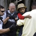 A Haitian boy holds onto his father as they approach an illegally crossing point, staffed by Royal Canadian Mounted Police officers, from Champlain, N.Y., to Saint-Bernard-de-Lacolle, Quebec, Monday, Aug. 7, 2017. Seven days a week, 24-hours a day people from across the globe are arriving at the end of a New York backroad so they can walk across a ditch into Canada knowing they will be instantly arrested, but with the hope the Canadian government will be kinder to them than the United States. (AP Photo/Charles Krupa)