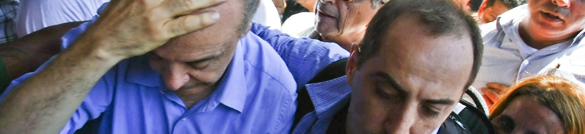 Brazil's presidential candidate Jose Serra (L) of the Social Democratic Party of Brazil protects his head after being "knocked silly" by a thrown object, during a rally in Campo Grande, 55 km from Rio de Janeiro's downtown, on October 20, 2010. Serra and rival Dilma Rousseff of the ruling Workers' Party, will face on October 31 in the run-off election. AFP PHOTO/Cesar Da Silva (Photo credit should read CESAR DA SILVA/AFP/Getty Images)