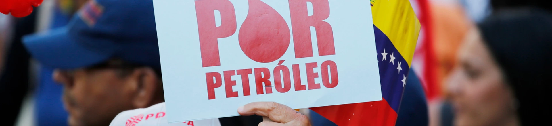 Manifestante segura uma placa onde se lê "Atacam por petróleo" durante um protesto em apoio a PDVSA em Caracas.