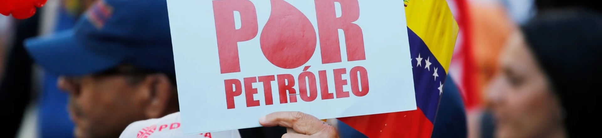 Manifestante segura uma placa onde se lê "Atacam por petróleo" durante um protesto em apoio a PDVSA em Caracas. Manifestante segura uma placa onde se lê "Atacam por petróleo" durante um protesto em apoio a PDVSA em Caracas.