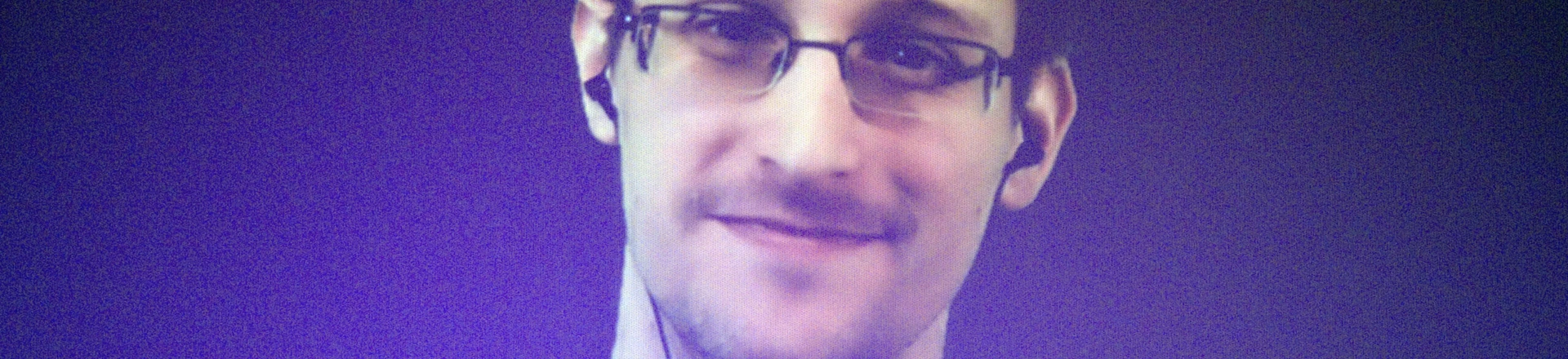 Former U.S. National Security Agency contractor Edward Snowden, who is in Moscow, is seen on a giant screen during a live video conference for an interview as part of Amnesty International's annual Write for Rights campaign at the Gaite Lyrique in Paris, France, Dec. 10, 2014. (AP Photo/Charles Platiau, Pool)