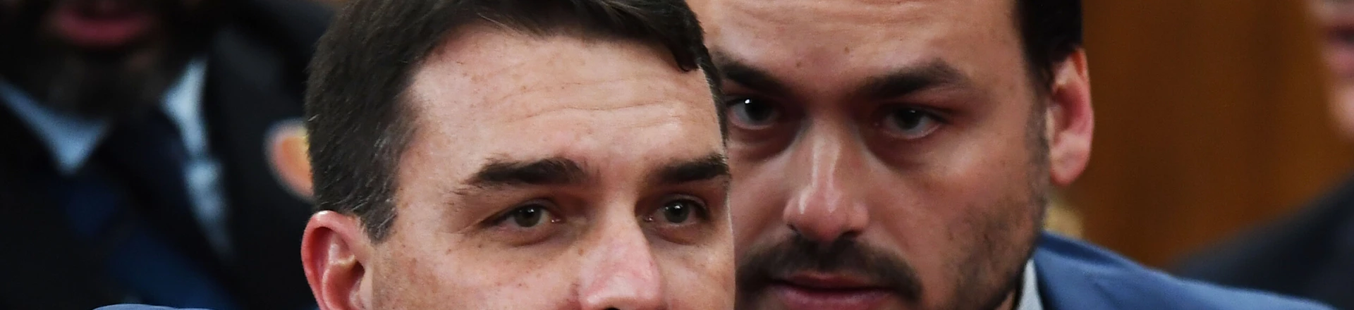Brazilian Senator for Rio de Janeiro Flavio Bolsonaro (L) and Councillor of Rio de Janeiro Carlos Bolsonaro attend their father Brazilian President-elect Jair Bolsonaro's ceremony to receive a diploma that certifies he can take office as president, at the TSE in Brasilia, on December 10, 2018. - Bolsonaro takes office on January 1, 2019. (Photo by EVARISTO SA / AFP)        (Photo credit should read EVARISTO SA/AFP/Getty Images) Brazilian Senator for Rio de Janeiro Flavio Bolsonaro (L) and Councillor of Rio de Janeiro Carlos Bolsonaro attend their father Brazilian President-elect Jair Bolsonaro's ceremony to receive a diploma that certifies he can take office as president, at the TSE in Brasilia, on December 10, 2018. - Bolsonaro takes office on January 1, 2019. (Photo by EVARISTO SA / AFP)        (Photo credit should read EVARISTO SA/AFP/Getty Images)