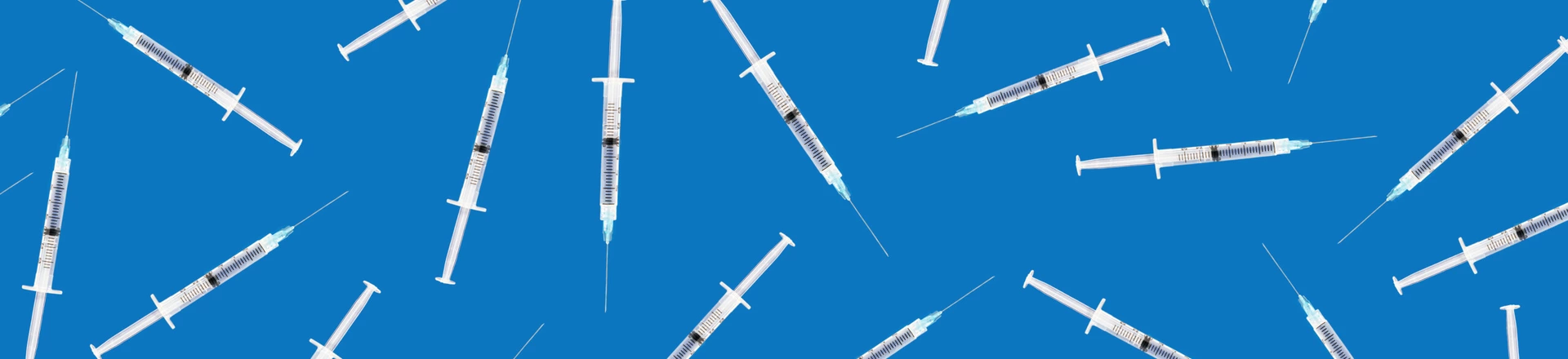 Many medical syringes scattered on blue background Many medical syringes scattered on blue background