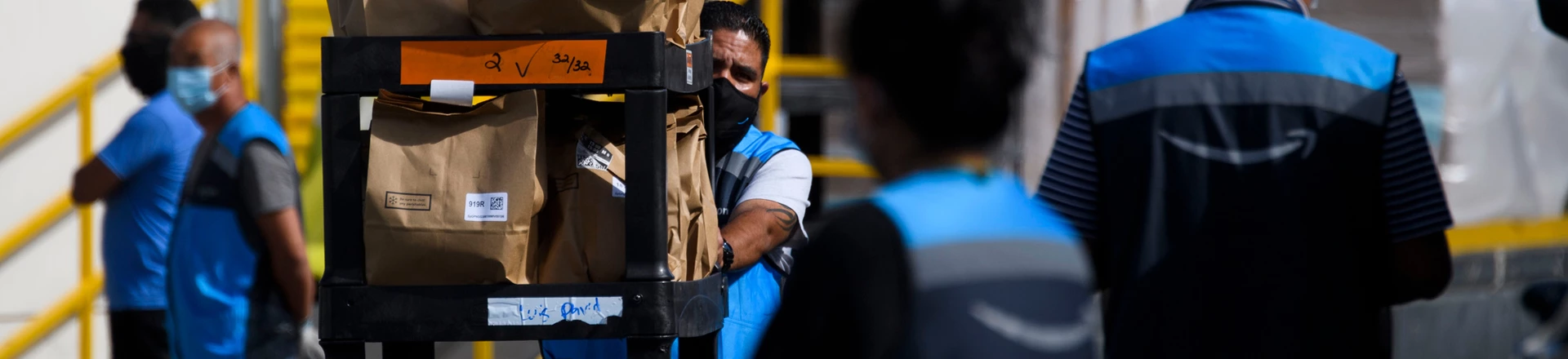 An Amazon.com Inc. delivery driver pushes a cart of groceries to load into a vehicle outside of a distribution facility on February 2, 2021 in Redondo Beach, California. - Jeff Bezos said February 1, 2021, he would give up his role as chief executive of Amazon later this year as the tech and e-commerce giant reported a surge in profit and revenue in the holiday quarter. The announcement came as Amazon reported a blowout holiday quarter with profits more than doubling to $7.2 billion and revenue jumping 44 percent to $125.6 billion. (Photo by Patrick T. FALLON / AFP) (Photo by PATRICK T. FALLON/AFP via Getty Images)