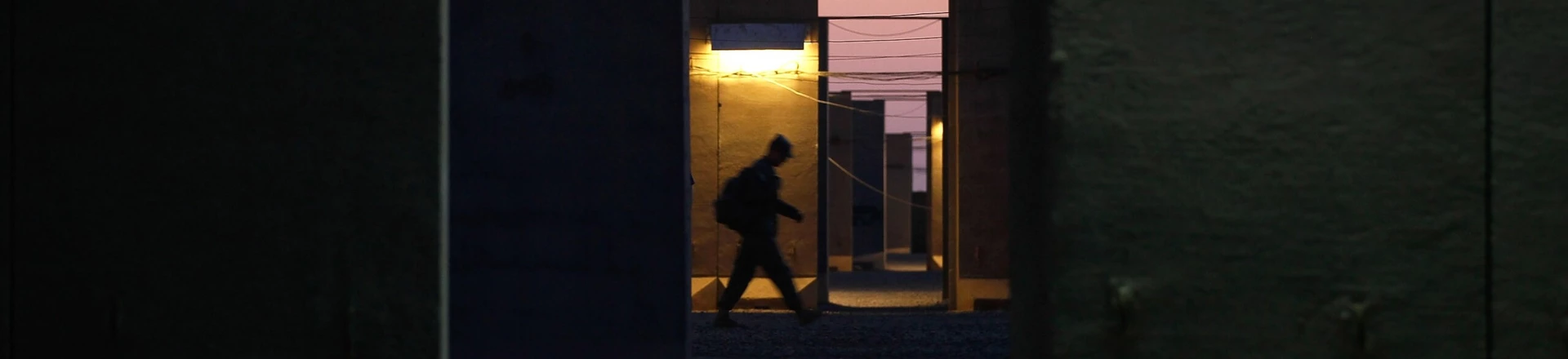 Um soldado do Exército dos EUA passa pelos muros de Camp Adder, na Base Aérea de Tallil, em 2 de dezembro de 2011.