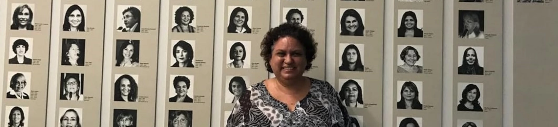 Lola Aronovich em frente a um mural com fotos de deputadas mulheres no Congresso Nacional, em Brasília.