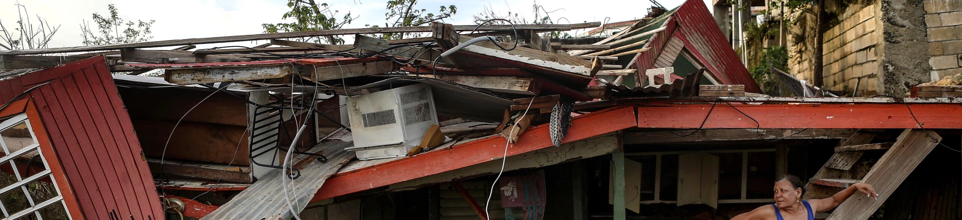 SAN ISIDRO, PUERTO RICO - OCTOBER 17:  Gladys Francisco stands in front of her destroyed home after U.S. soldiers unloaded food and water, provided by FEMA, to residents in the neighborhood still without grid electricity or running water on October 17, 2017 in San Isidro, Puerto Rico. The food and water delivery mission included U.S. Army, U.S. Coast Guard and Puerto Rico Hacienda forces. Residents said this was the first official governmental delivery of food and water to the community, nearly four weeks after the hurricane hit. Puerto Rico is suffering shortages of food and water in areas and only 17.7 percent of grid electricity has been restored. Puerto Rico experienced widespread damage including most of the electrical, gas and water grid as well as agriculture after Hurricane Maria, a category 4 hurricane, swept through.  (Photo by Mario Tama/Getty Images) SAN ISIDRO, PUERTO RICO - OCTOBER 17:  Gladys Francisco stands in front of her destroyed home after U.S. soldiers unloaded food and water, provided by FEMA, to residents in the neighborhood still without grid electricity or running water on October 17, 2017 in San Isidro, Puerto Rico. The food and water delivery mission included U.S. Army, U.S. Coast Guard and Puerto Rico Hacienda forces. Residents said this was the first official governmental delivery of food and water to the community, nearly four weeks after the hurricane hit. Puerto Rico is suffering shortages of food and water in areas and only 17.7 percent of grid electricity has been restored. Puerto Rico experienced widespread damage including most of the electrical, gas and water grid as well as agriculture after Hurricane Maria, a category 4 hurricane, swept through.  (Photo by Mario Tama/Getty Images)