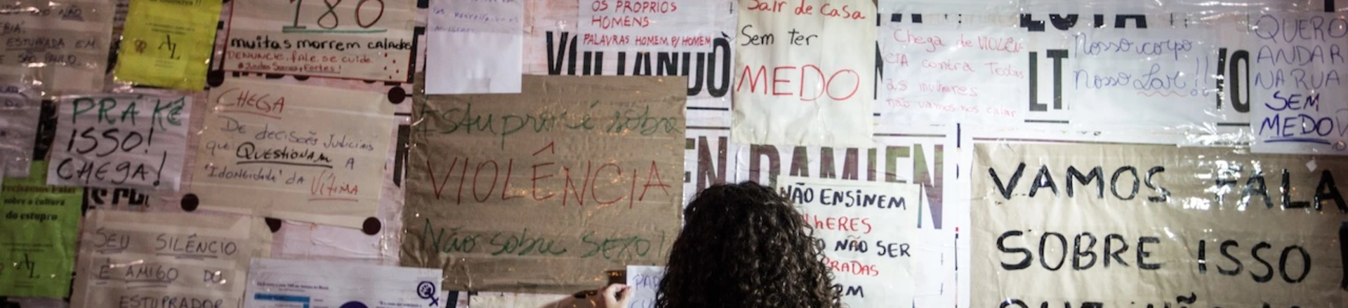 Uma garota cola cartazes contra estupro em tapume no MASP, na avenida Paulista. São Paulo, maio de 2016.